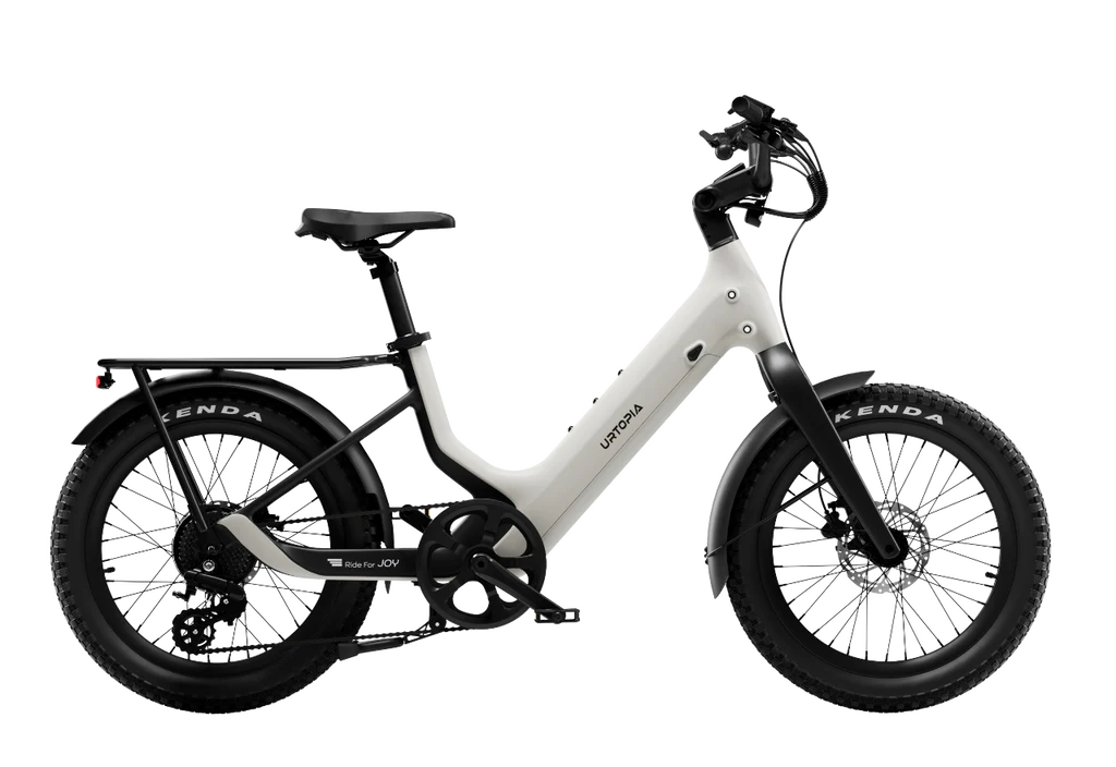 The Urtopia Carbon Joy Ultra by Urtopia, a white electric cruiser bike with thick tires, step-through frame, rear cargo rack, and disc brakes, is shown from the side on a white background.