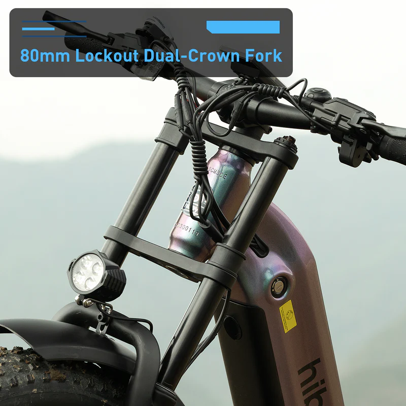 Close-up of the Hiboy EX11 commuter e-bike's 80mm lockout dual-crown fork, handlebars, front light, and cables by Hiboy, set against a blurred outdoor background.