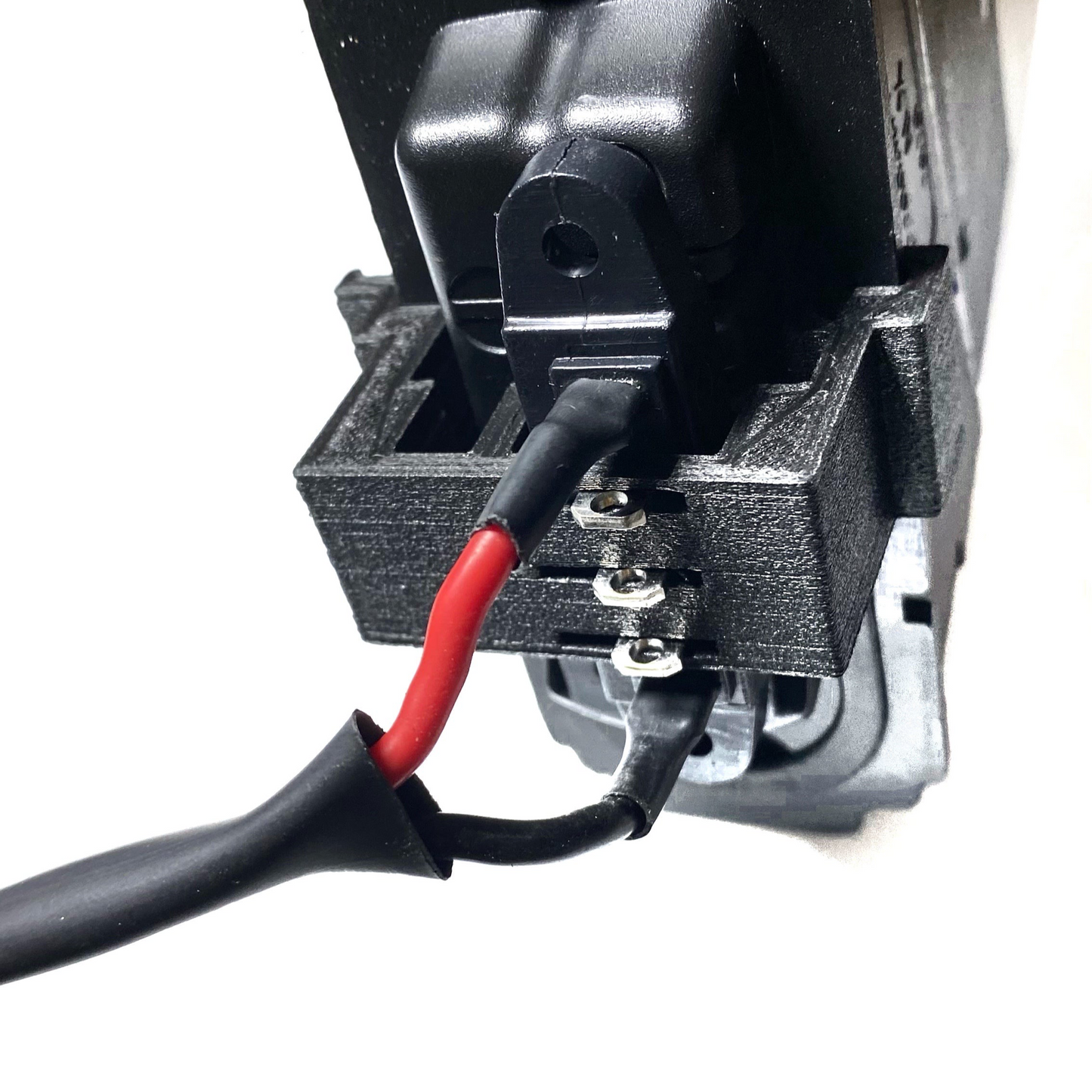Close-up of electrical wires connected to a black plastic terminal block, featuring the ElectricAllWheel Factory External Battery XT60 Adapter for Lectric Fit 1.0, 2.0, 3.0, and lite e-bikes.