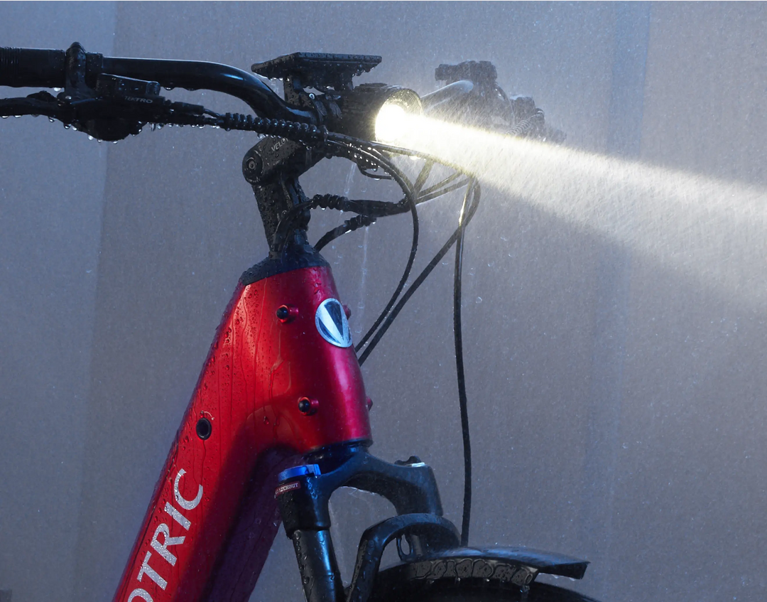 A Velotric Discover 2 bicycle being cleaned with a high-pressure water spray.