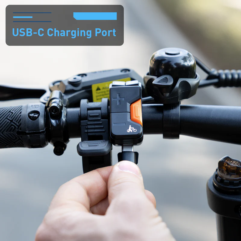 A hand plugs a USB-C cable into the labeled "USB-C Charging Port" on the handlebar of a Hiboy - EX11 commuter e-bike by Hiboy.