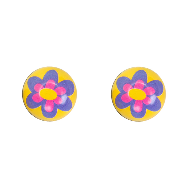 Two 'Trik Topz - Purple Flower' yellow circular buttons, featuring pink and purple flower designs in the center, shown against a white background.