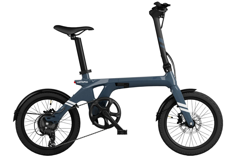 The Urtopia Carbon Fold 1 electric folding bike features a sleek carbon fiber frame, small wheels, and a compact design in dark blue, showcasing its visible chain and gears.