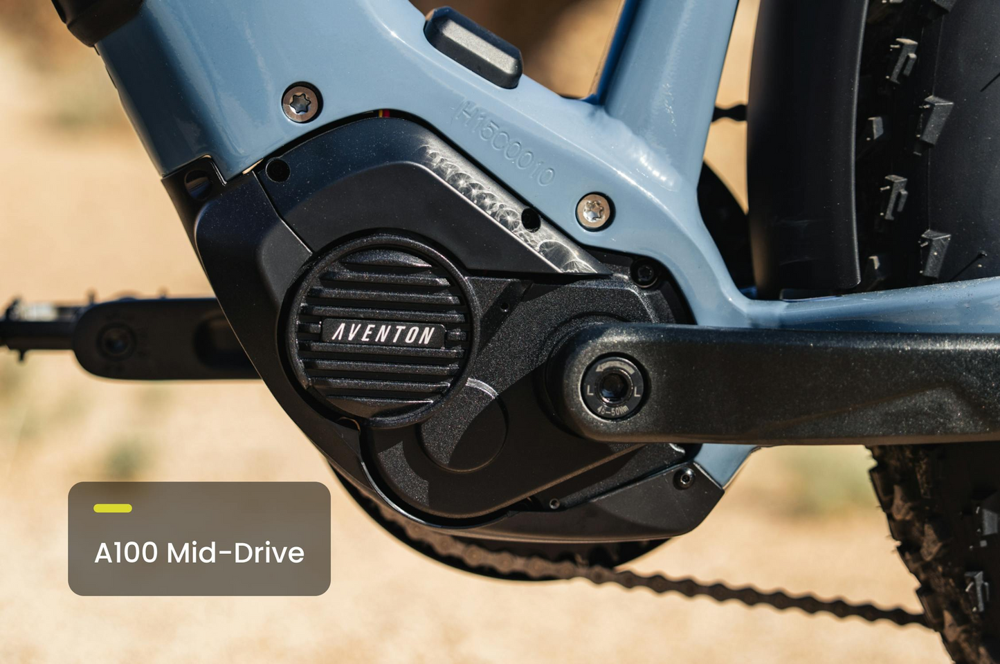 Close-up of a Tampa Bay eBikes Aventon - Aventure M mid-drive fat tire eBike motor mounted on the frame, highlighting its high-torque performance. Pedals and a portion of the tire are also visible.