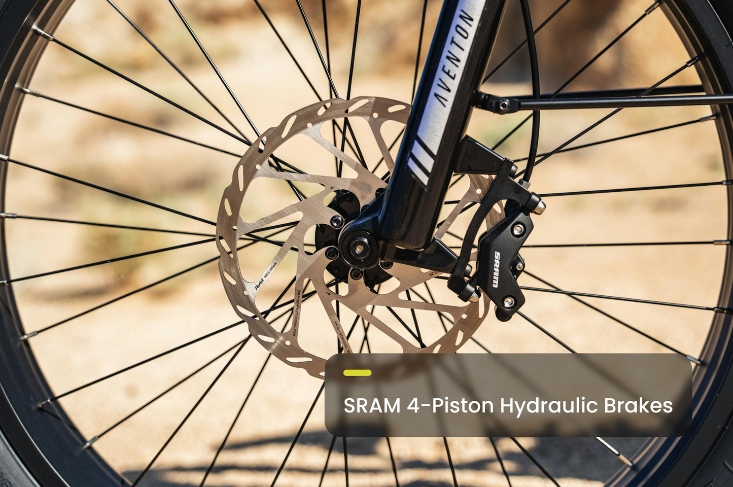 Close-up of a bicycle wheel showing a disc brake rotor and SRAM 4-piston hydraulic caliper on the high-torque Aventon - Aventure M mid-drive fat tire eBike by Tampa Bay eBikes.