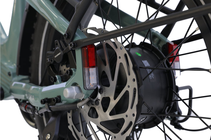 Close-up view of the AIMA - Big Sur Sport 2.0 e-bike’s rear wheel, highlighting its disc brake rotor, motor hub, and rear lights against a white background.