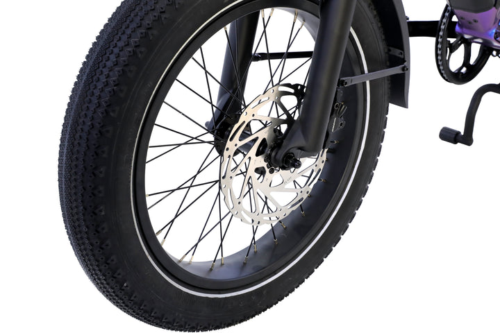 Close-up of the AIMA - Big Sur U Cargo’s front wheel, featuring a thick tread tire, black spokes, and a disc brake mounted on the fork.