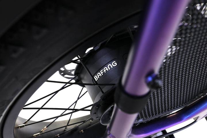 Close-up of the AIMA - Big Sur U Cargo's bicycle wheel featuring a Bafang hub motor, purple fork, and black spokes—ideal for a powerful and reliable electric cargo bike from AIMA.