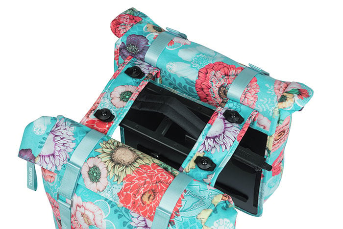 The Basil Bloom Field Double Pannier by Basil features a floral pattern and black plastic interior supports, shown open to reveal its inner compartments.