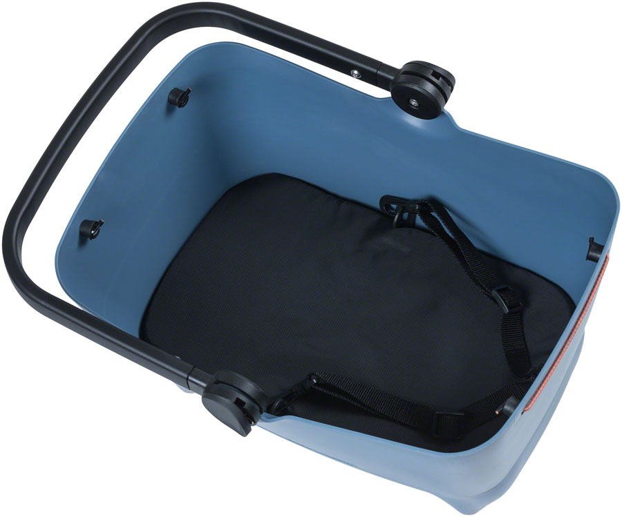The Basil Buddy Dog Basket MIK by Basil is a blue plastic basket with a black handle and padded black insert with straps, perfect for eBike use; MIK compatible for secure, easy mounting.