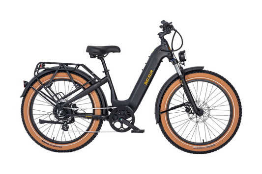 The AIMA - Big Sur, a sleek black electric eBike with tan tires from the brand AIMA, showcases a powerful motor. It's designed as an all-terrain companion and is equipped with a sturdy rear rack and reliable disc brakes, presenting an elegant side profile.