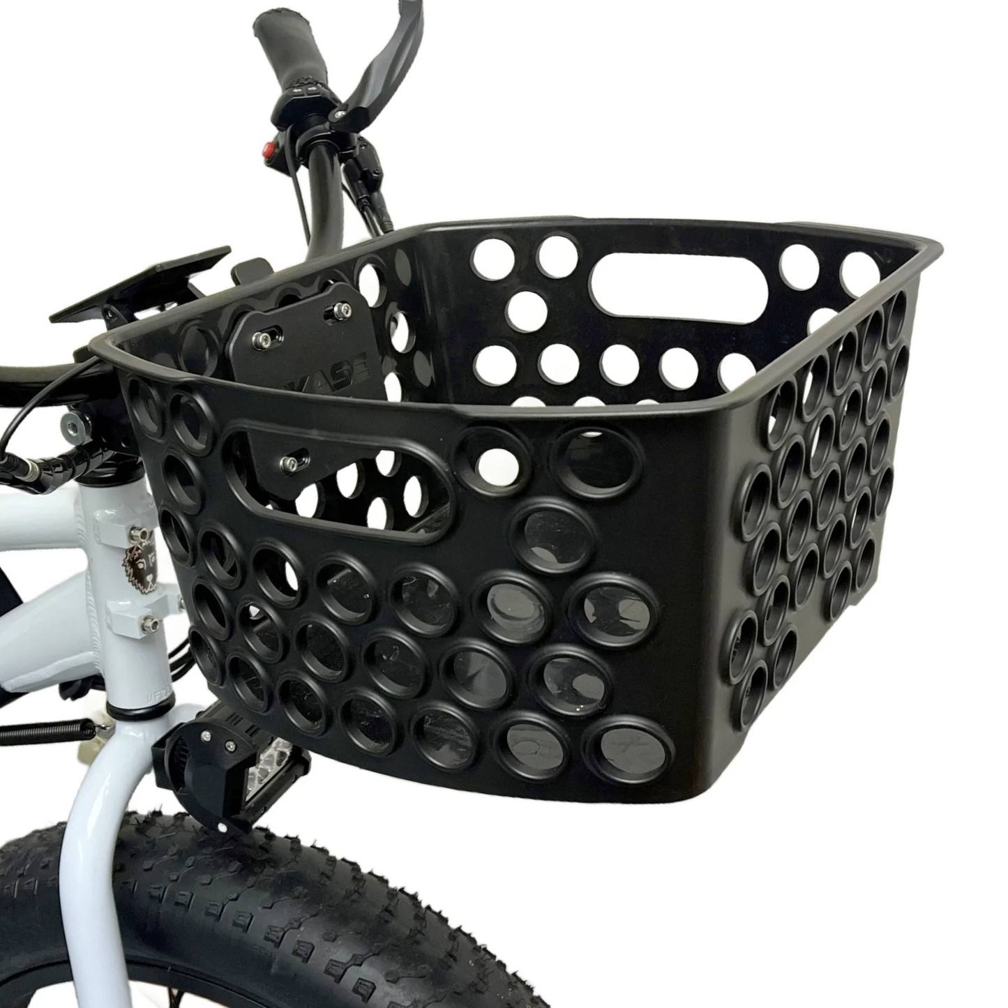 A black plastic basket with circular cutouts, known as the Front Basket by Bikase, is attached to the handlebars of a white bicycle using an adjustable clamp.