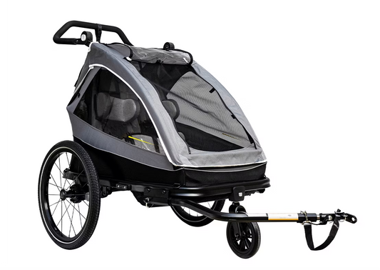 The Child Trailer - Aventon Double Seat by Aventon features a sleek black and gray design with double seats, a mesh cover, handbrake, and comfortable seating. Its foldable frame ensures easy storage and transport.