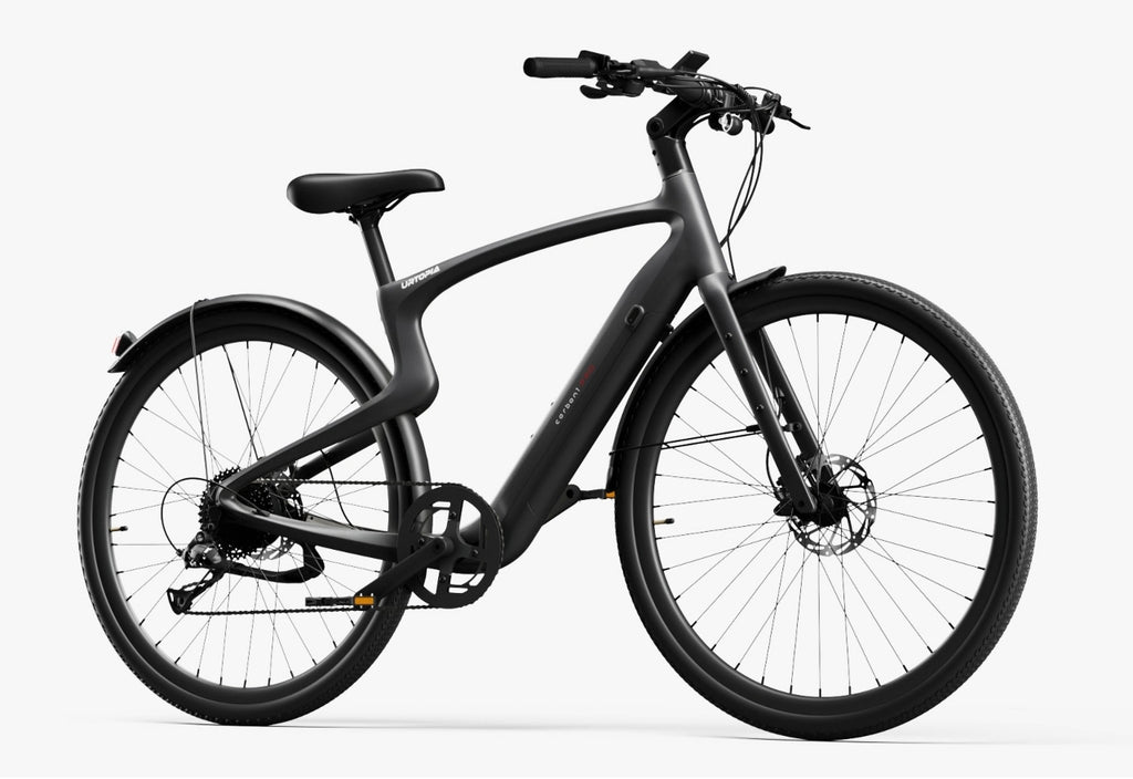 The Urtopia - Carbon Classic eBike by Urtopia is shown in matte black with a streamlined frame, flat handlebars, disc brakes, and fenders, viewed from the side against a plain white background.
