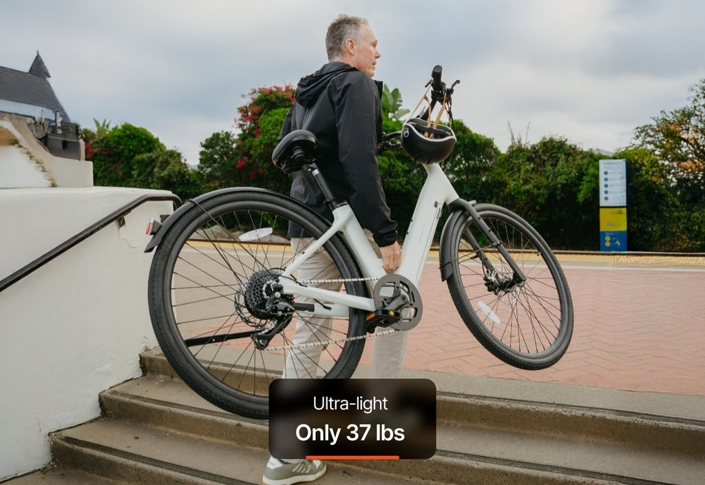 A man carries the Urtopia - Carbon Classic Step-Thru eBike by Urtopia up outdoor steps; a label reads, "Ultra-light Only 37 lbs.