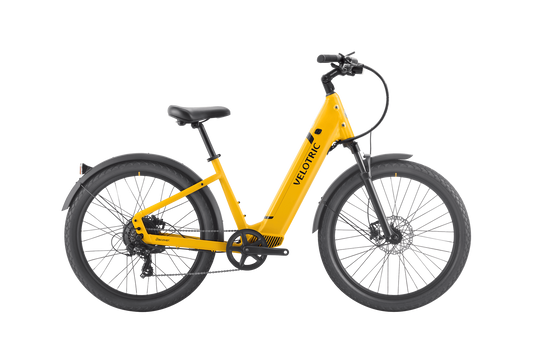 A yellow Velotric - Discover 1 Plus commuter e-bike with a step-through frame, black seat, and black tires on a white background. This stylish model features the powerful Velopower H50 drive system, making it perfect for everyday commuting.