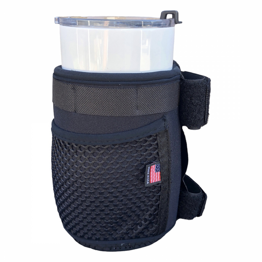 The Color Splash Drink Holder in black features a mesh pocket, attached strap, and a small American flag patch, shown here holding a clear plastic tumbler.