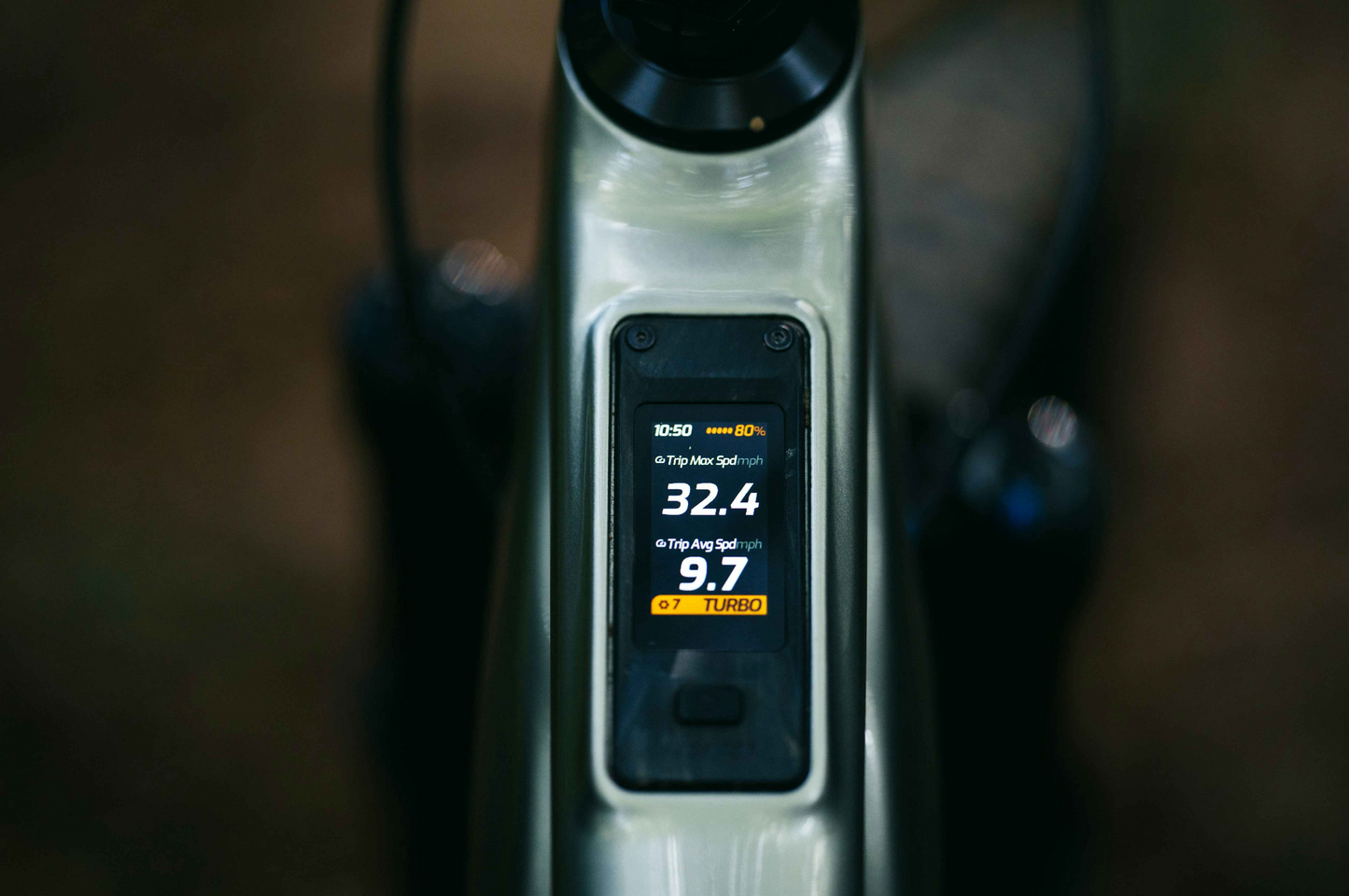 Close-up of an Aventon Current EXP display by Aventon, showing battery at 80%, speed at 32.4 km/h, mode set to "Turbo," and a secondary screen reading of 9.7.