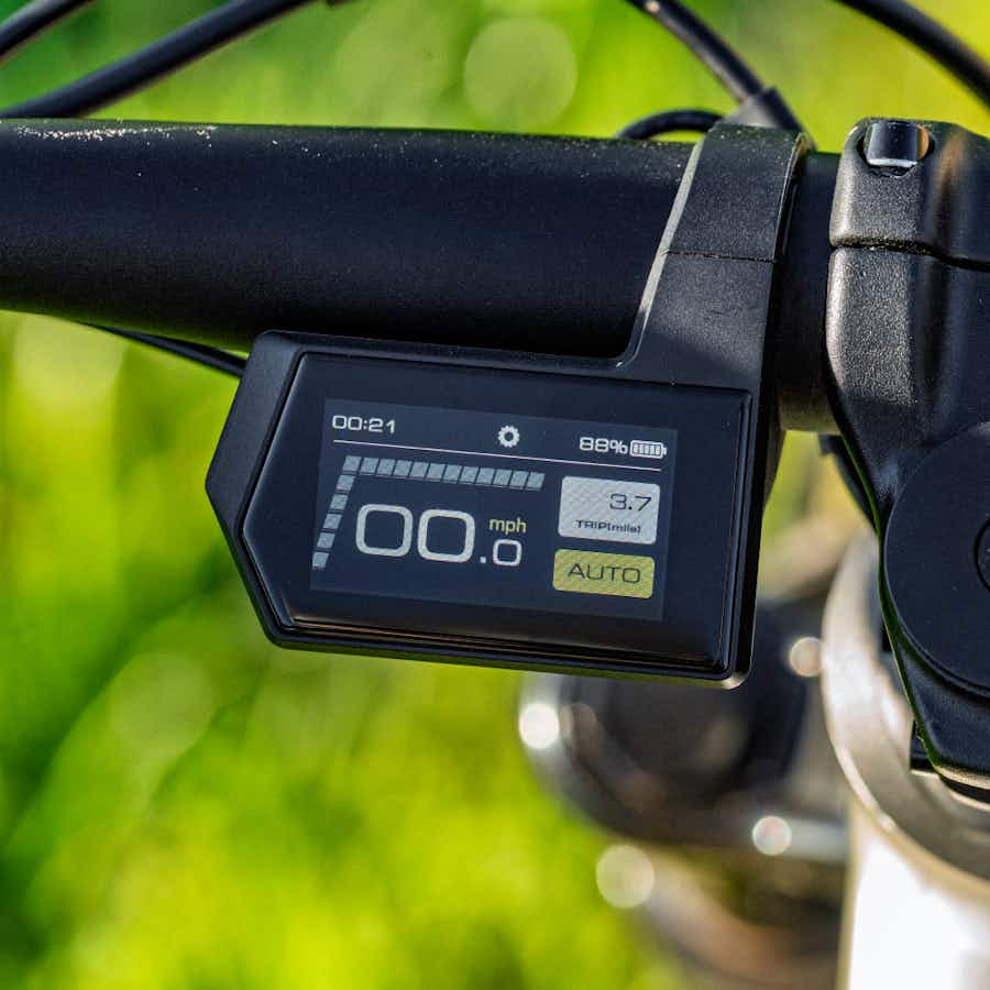 Close-up of the Aventon Ramblas ADV electric mountain bike display by Aventon, showing 0.0 mph speed, 89% battery, 3.7-mile trip distance, and AUTO mode—powered by a responsive mid-drive motor.