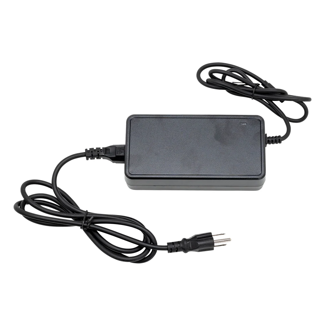 A black Lectric Charger - Lectric - 3 Pin features a rectangular body, two attached cables, and a standard two-prong plug—an essential accessory for your Lectric eBike.