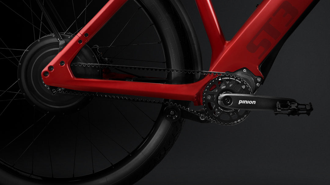 Close-up of a red exclusive Stromer - ST3 Pinion Launch Edition eBike's rear wheel and gear system, featuring a black Pinion gear box and chain, set against a dark background.