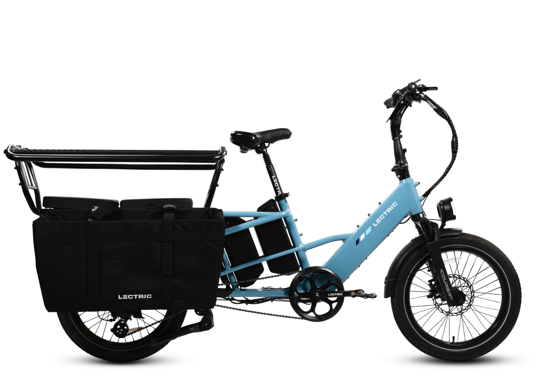 Light blue Lectric XPedition2 Cargo Electric Bike with black side bags, rear cargo rack, step-through frame, and front suspension, shown against a white background. Available at Tampa Bay eBikes.