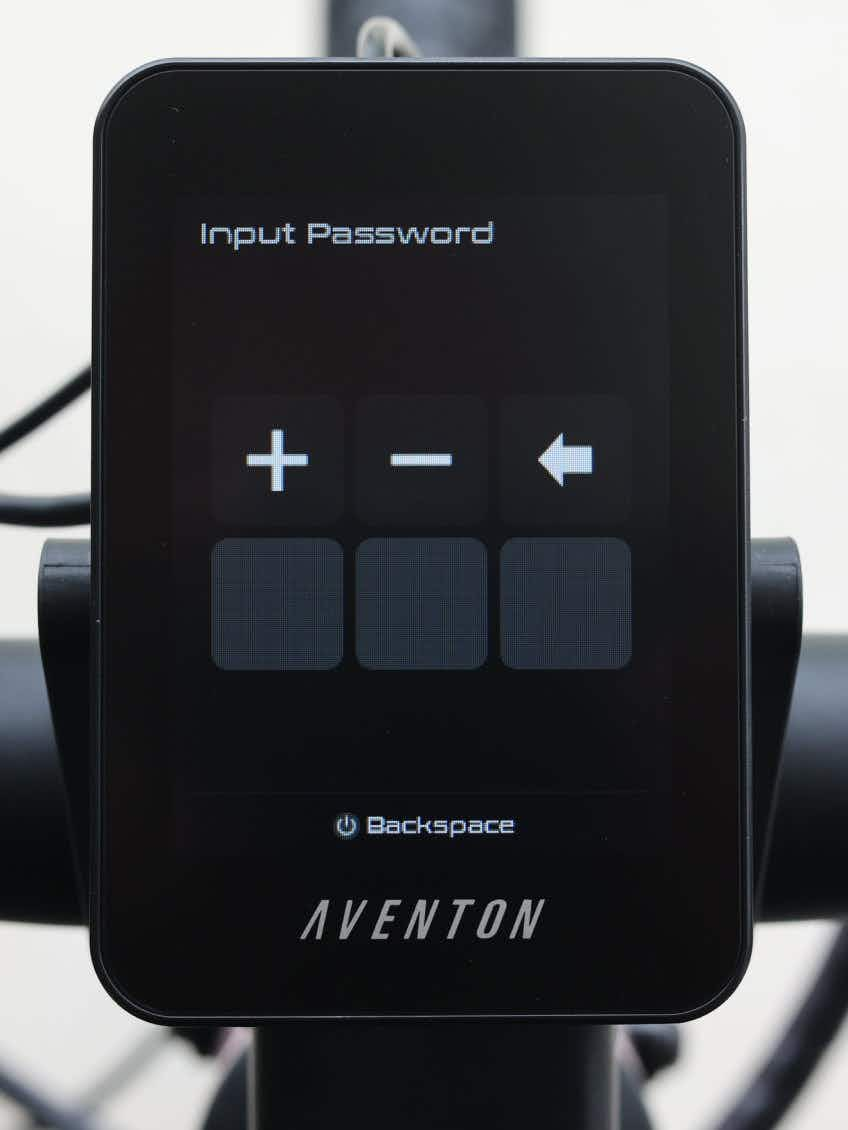 The Aventon Pace 5 REC Step-Through electric bike features a digital display screen with a password input interface and plus, minus, and backspace buttons. The brand name "Aventon" appears at the bottom of this comfort cruiser’s display.