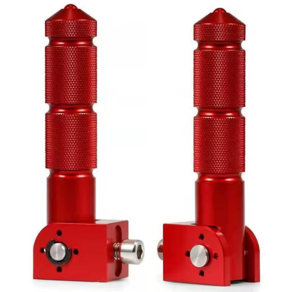 Two red, textured metal Color Splash Rear Pegs with cylindrical handles and rectangular bases, featuring adjustment knobs and screws—perfect as eBike footrests or folding bicycle pegs for added comfort and stability.