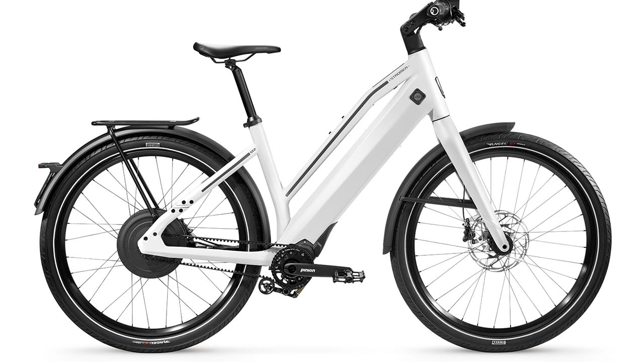 White Stromer ST2 Pinion Comfort electric bike with step-through frame, mounted battery, rear rack, and disc brakes against a white background.