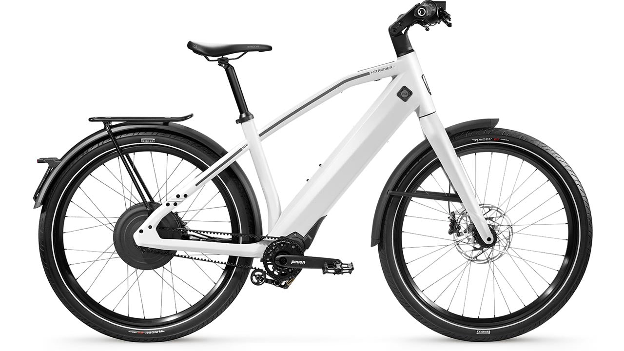 Stromer ST2 Pinion Sport electric bicycle with a sleek frame, equipped with front and rear fenders, disc brakes, and a rear cargo rack, displayed on a white background.