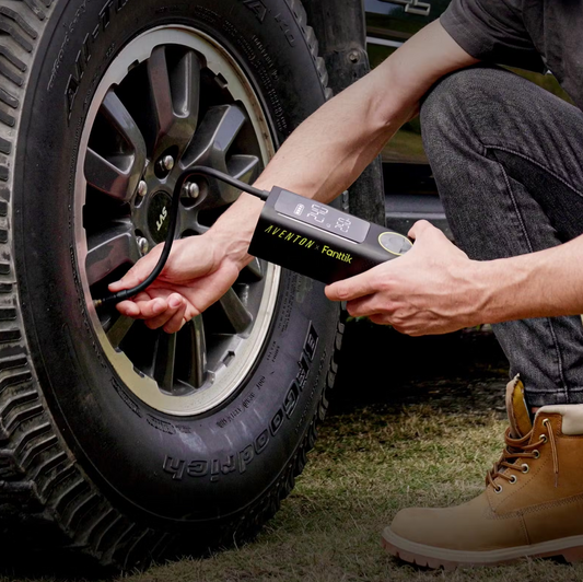 A person using a Tampa Bay eBikes portable air pump to check the air pressure of a vehicle's tire.