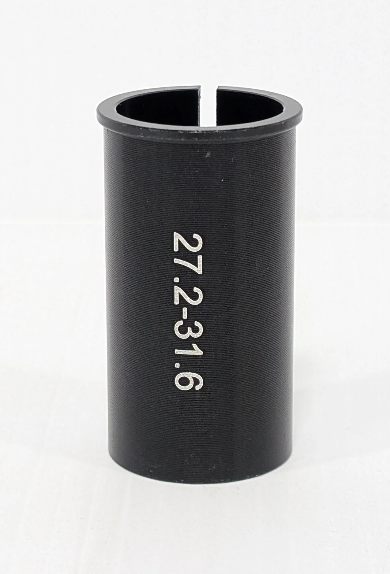 The BiKASE Seat Post Shim, a black cylindrical adapter, features "27.2-31.6" in white text, serving as a reliable bicycle accessory against a plain background.