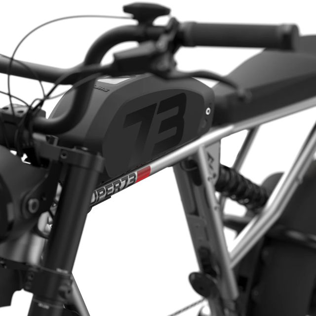 Here’s a revised version using your product data: Close-up view of the Super 73 SUPER73-R Brooklyn SE electric bike, showcasing its durable frame, integrated battery compartment, unique “73” branding, and a section of the advanced full suspension system.