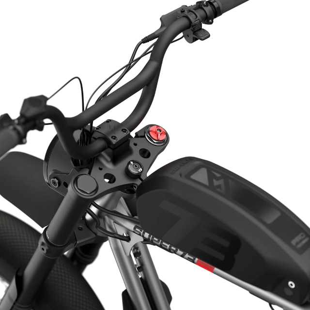 Close-up view of the Super 73 SUPER73-R Brooklyn SE electric bike’s handlebars, display, and battery compartment, emphasizing the control interface and textured grips. The image showcases the full suspension system against a clean white background.
