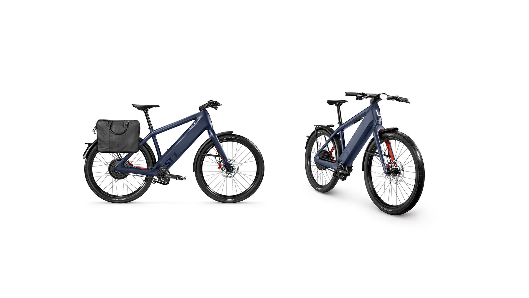 Two Stromer ST7 Alinghi Red Bull Racing Edition electric bicycles shown from different angles, featuring blue frames, rear saddlebags, and mounted black tires on a white background. These eBikes are equipped with SYNO Drive S motors.