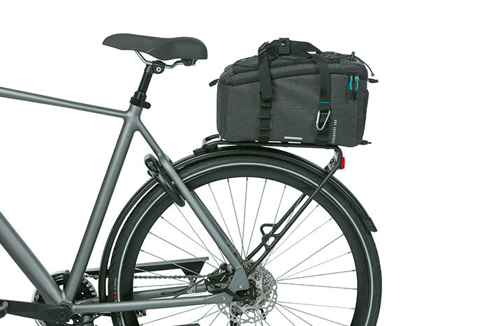 A side view of a bicycle with a gray frame, featuring a black rear rack that holds a Basil Bag - Basil Discovery 365 MIK secured with straps and attached using an MIK adapter plate.