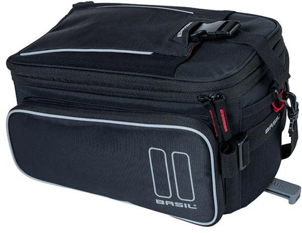 A black Bag - Basil Sport Design MIK - Black with a white reflective pattern, featuring multiple zippers and compartments. The bag, compatible with the MIK system, includes a shoulder strap and clip for easy attachment to your luggage carrier from Basil.