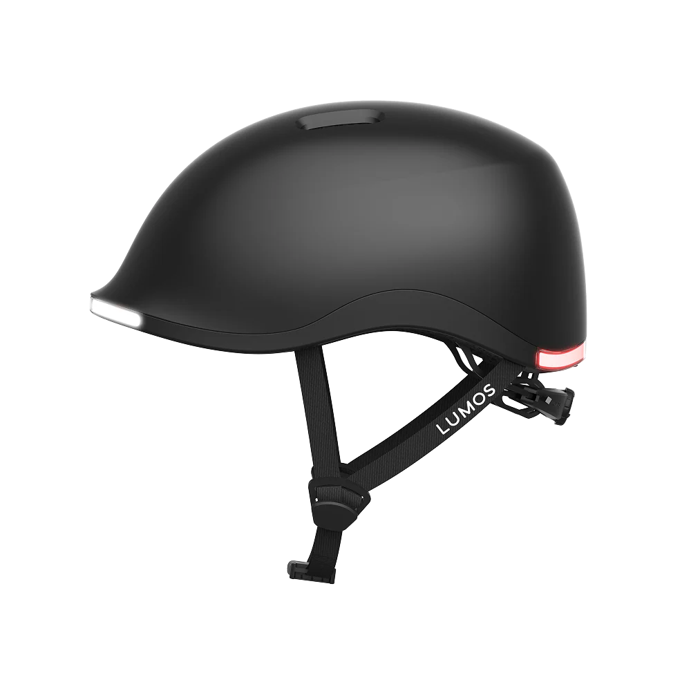 The Lumos NYXEL is a matte black smart bike helmet with integrated front and rear LED lights, adjustable straps, and the Lumos brand name visible on the side.