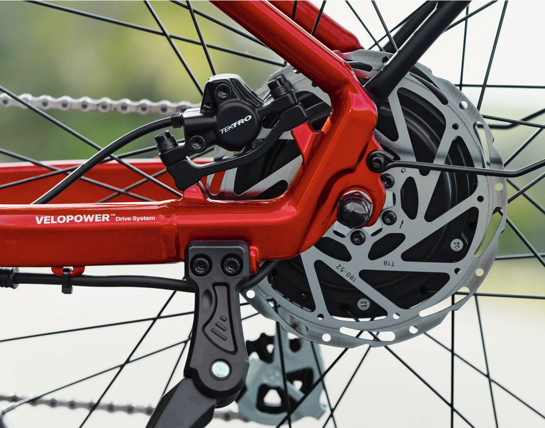 Close-up of a Velotric Discover 2 red electric bike frame showing the disc brake system and drive train.
