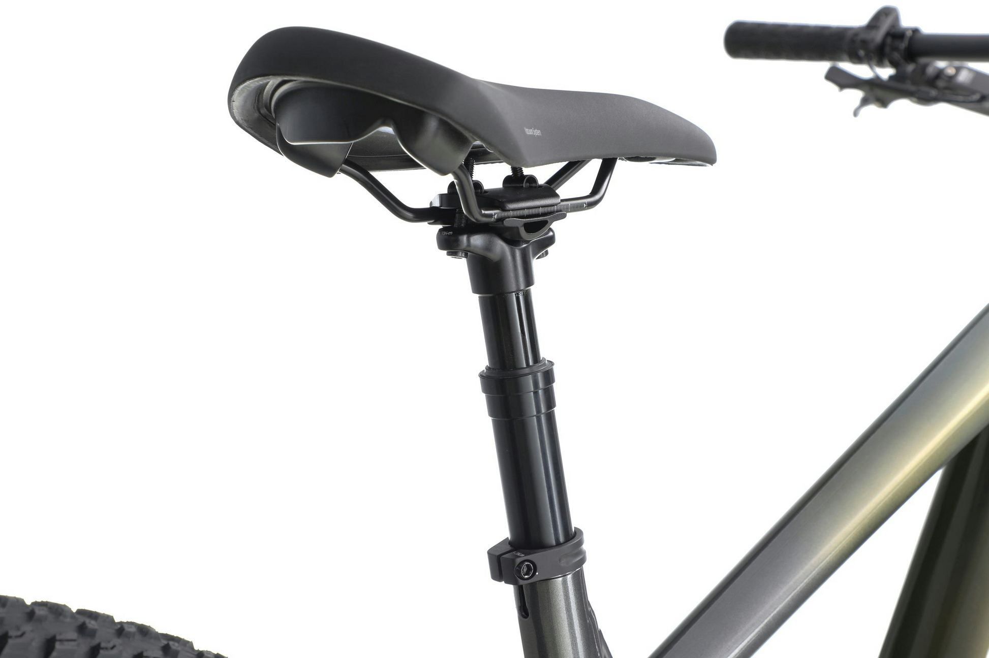 Black bicycle saddle mounted on a seatpost, with a partial view of an Aventon - Ramblas eMTB frame and handlebars in the background.