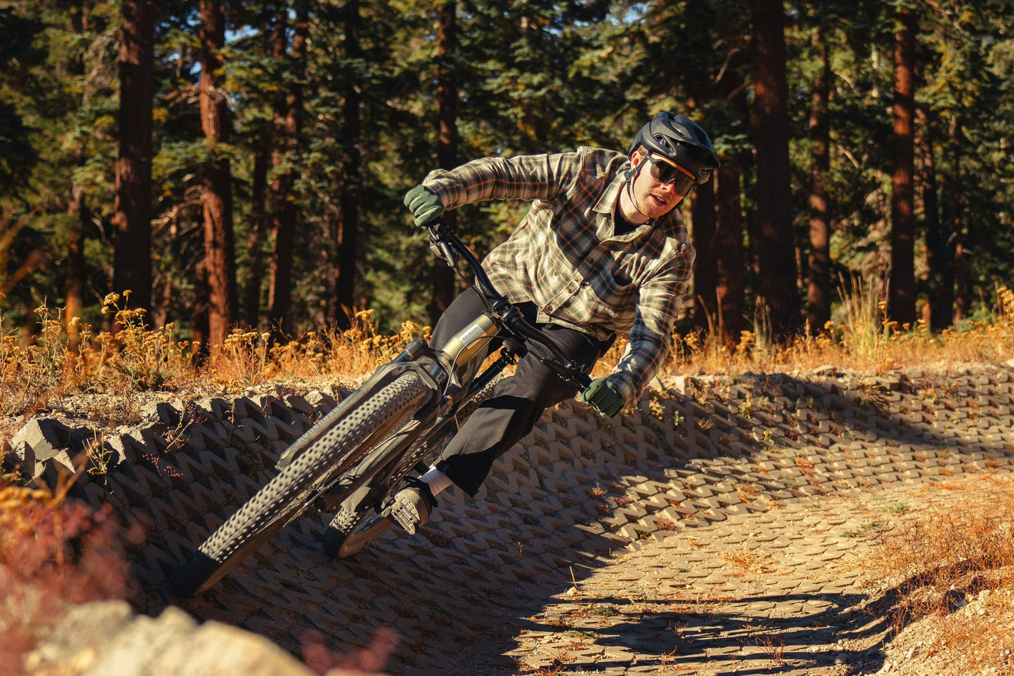 Mountain biker maneuvering through a turn on a forest trail on an Aventon Ramblas eMTB from Aventon.