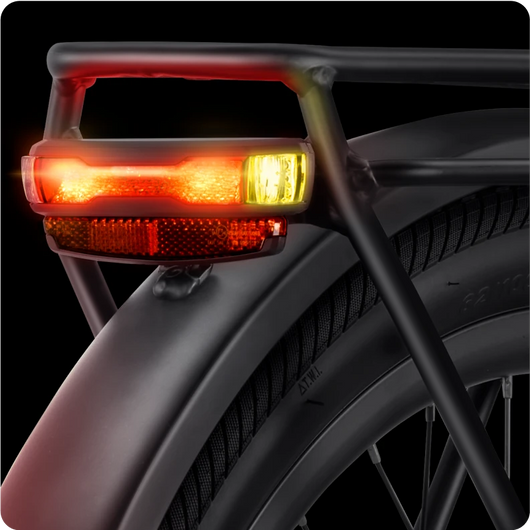 Illuminated red and amber Velotric Discover 2 bike tail light mounted on a bicycle's seat post.