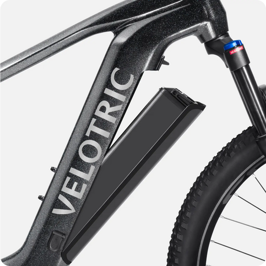 Close-up of a black Velotric Summit 1 eBike frame labeled "Velotric Summit 1," featuring a prominent battery pack and a rear wheel.