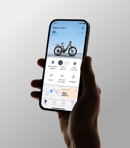 A hand holds a smartphone with the Segway app, showing bike controls, battery status, and trip details for the Segway - Xafari Electric Bike. Enjoy extended range and strong motor performance at your fingertips.