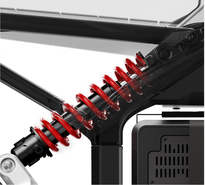 A close-up of a red coil spring is suspended between black metal components, likely part of the high-performance Segway - Xyber eBike, powered by a 6,000 W motor.