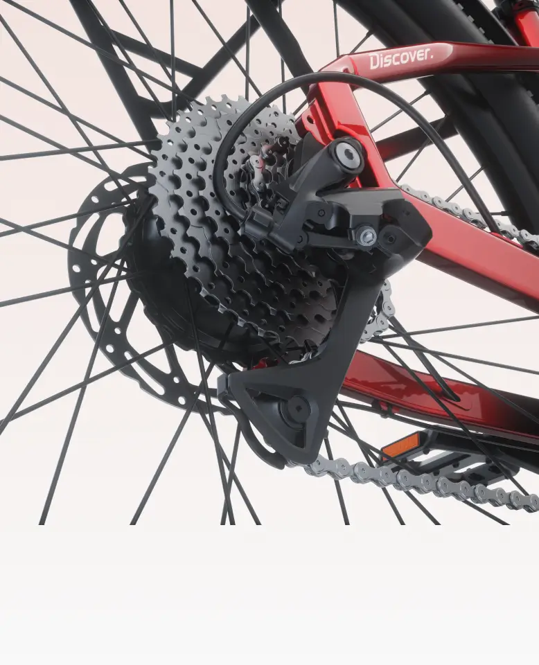Close-up of the Velotric Discover 3’s rear derailleur, gear cassette, and chain on its red frame labeled "Discover"—the Velotric eBike made for style-conscious commuters in Tampa Bay.