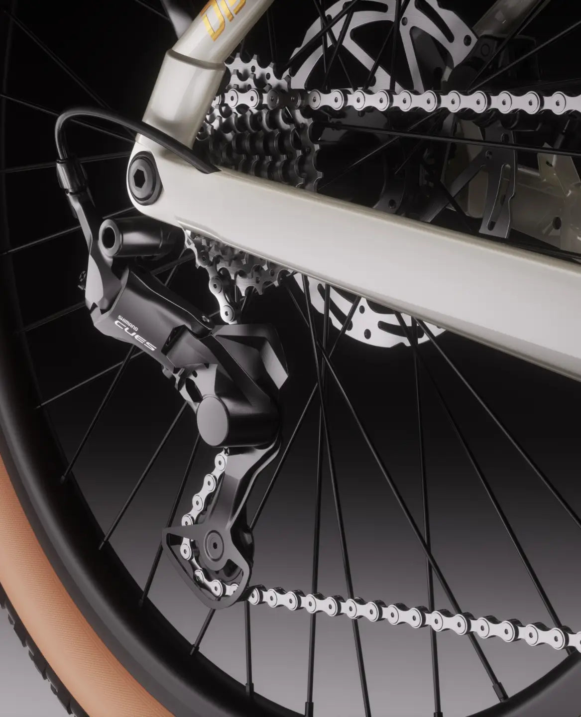 Close-up of the Velotric Discover M’s rear derailleur, chain, and cassette. The light brown sidewall tire adds style to this Velotric comfort commuter eBike against a neutral background.