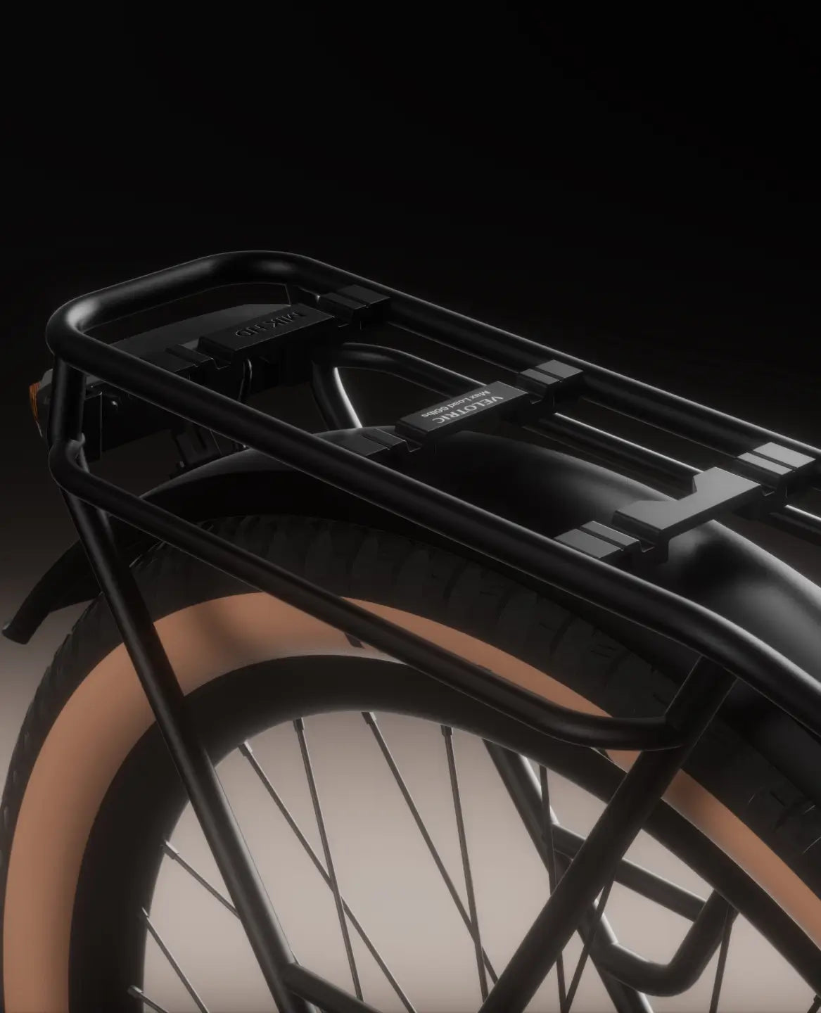 Close-up of the Velotric Discover M’s rear wheel, with a black cargo rack above its tan sidewall tire—highlighting Velotric’s sleek comfort commuter eBike design against a dark backdrop.